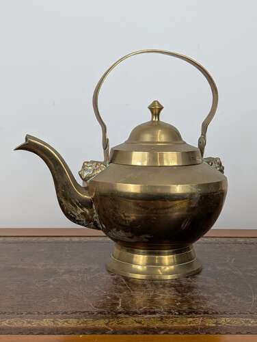 Victorian brass swing handle kettle with lion head mounts and tinned interior