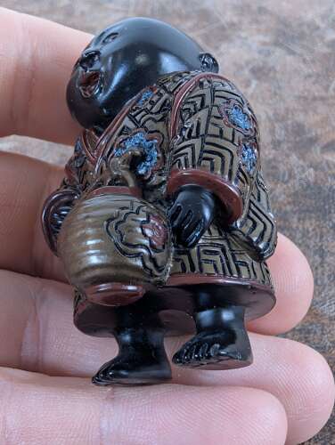 Japanese lacquered wood netsuke of a laughing boy with kettle